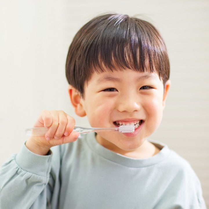 jeune garcon se brosse les dents